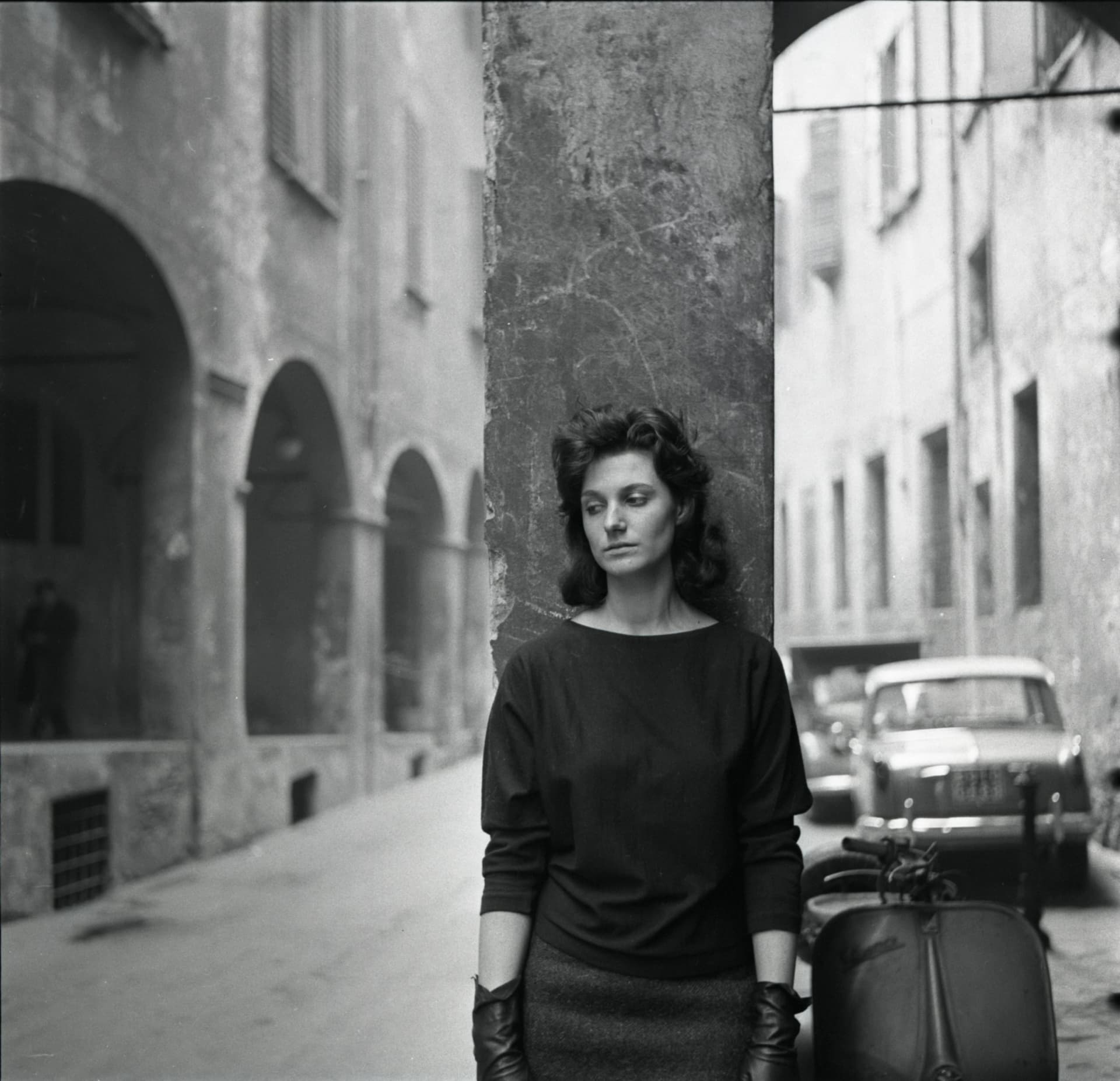 Una giovane donna con sguardo malinconico, appoggiata a un portico del centro storico di Bologna. Foto di Antonio Masotti © Cineteca