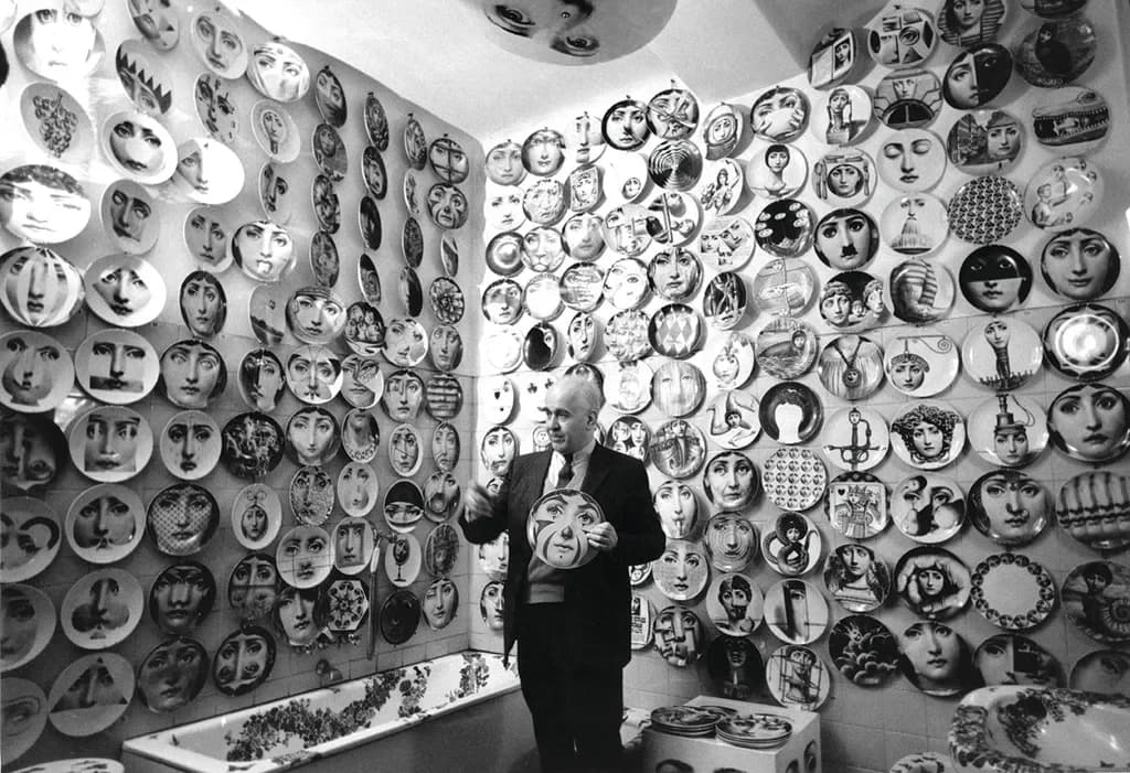 Piero Fornasetti circondato dai suoi piatti che omaggiano il volto, che riteneva perfettamente proporzionato, di Lina Cavalieri.