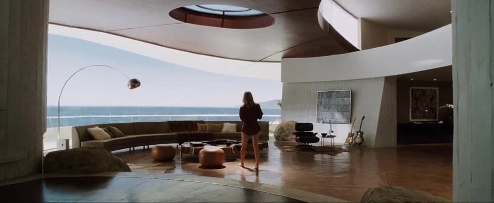 L'incredibile salotto della Villa di Iron Man, arredata con l'iconica Lampada ad Arco dei fratelli Castiglioni per Flos. Esempio delle numerose volte in cui design e cinema si sono incontrati.